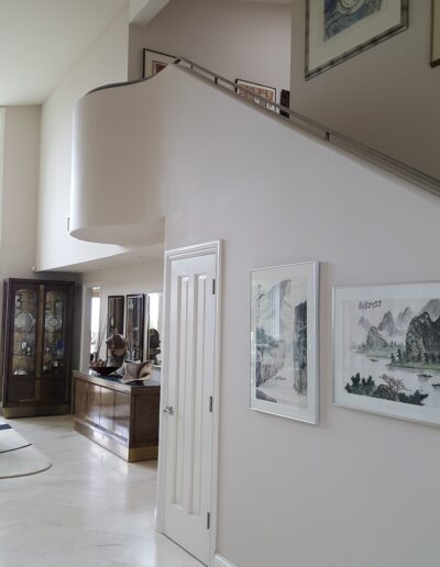 A living room with a white floor and a staircase.