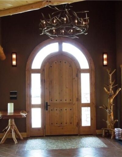 A room with a wooden door and a chandelier.