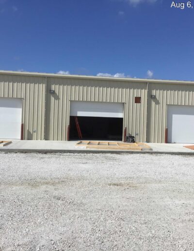 An industrial building with two garage doors.